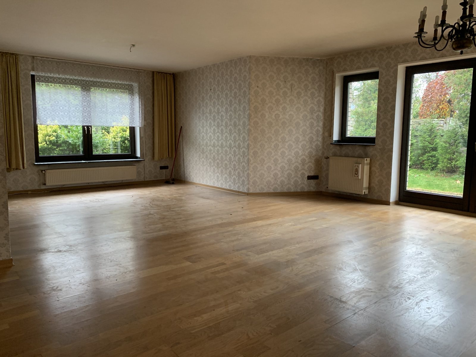 Leeres, helles Wohnzimmer mit Holzboden nach der Räumung